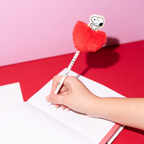 Esferográfica Erik Snoopy Love Season com pompom a ser utilizada para escrever num caderno